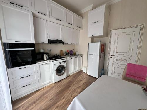 a kitchen with white cabinets and a white refrigerator at Sumqayit Kristal 3 in Sumqayıt