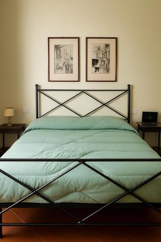 a bedroom with a bed with two pictures on the wall at L'orologio matto in Marina di Carrara