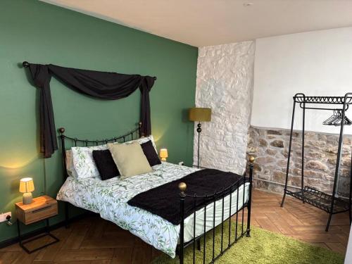 a bedroom with a black bed and a green wall at Wonrek in Penzance
