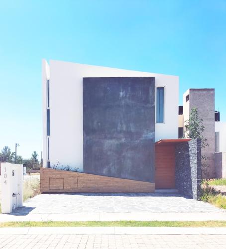 a white house with a wooden door at Loft SB in Aguascalientes