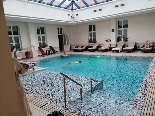 a person laying in a swimming pool in a building at Tri srca in Banja Koviljača