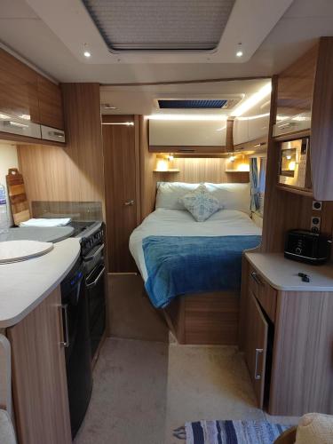 a small room with a bed and a kitchen at Country Roost in High Wycombe