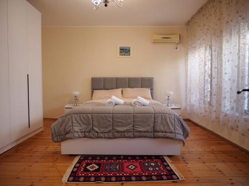 a bedroom with a large bed and a rug at Fisi Heritage Home in Shkodër