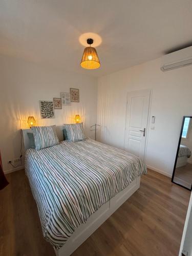 - une chambre avec un lit et un éclairage dans l'établissement Magnifique 2 pièces, à Nice