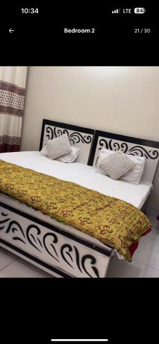 a bed with black and white sheets and pillows at Lovely 2 Bedroom Furnished Apartments in Multan