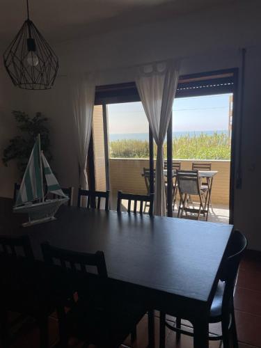 a dining room with a table and chairs and a window at Carminho beach house in Vila do Conde