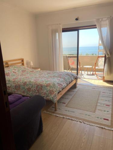 a bedroom with a bed and a view of the ocean at Carminho beach house in Vila do Conde