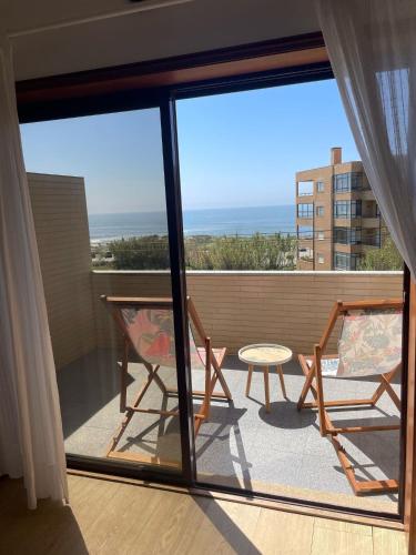 a balcony with two chairs and a table at Carminho beach house in Vila do Conde