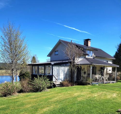 a house with a large yard and a lake at Linnåsen stuga in Rottneros