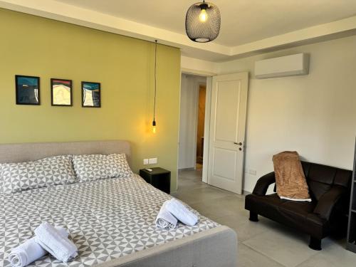 a bedroom with a bed and a chair at Brand new Gozo escape - Ir-Ramla Apartment, Nadur in Nadur