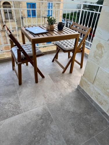 a wooden table and two chairs on a patio at Brand new Gozo escape - Ir-Ramla Apartment, Nadur in Nadur