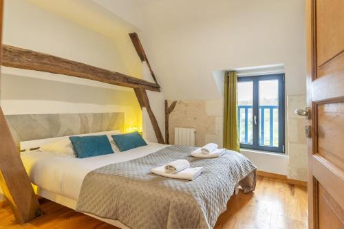 une chambre avec un grand lit avec des serviettes dessus dans l'établissement Maison de la Dube - Valley view, à Bourré