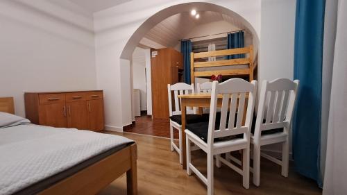 a room with a table and chairs and a bed at Liść Klonu in Polańczyk