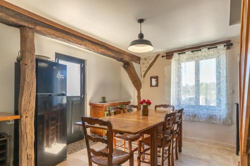 une salle à manger avec une table et un réfrigérateur dans l'établissement Maison de la Dube - Valley view, à Bourré