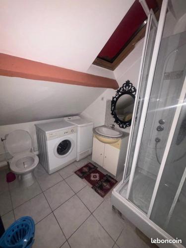 une petite salle de bains avec toilettes et lave-linge. dans l'établissement Studio en location, à Angerville