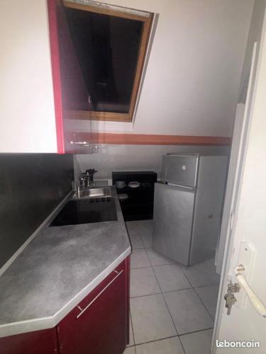 une petite cuisine avec un évier et un réfrigérateur dans l'établissement Studio en location, à Angerville