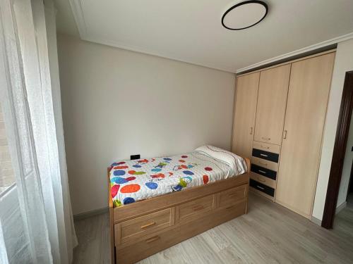 een kleine slaapkamer met een bed en een kast bij Luanco para vivir y disfrutarlo VUT7223AS in Luanco