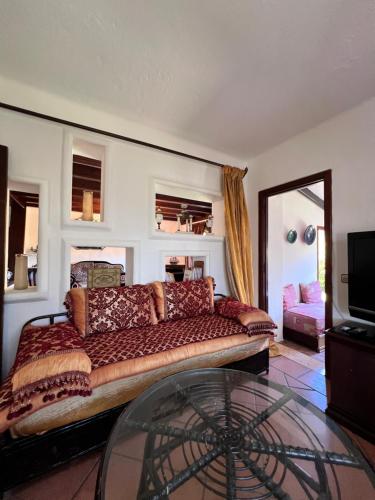 a living room with a couch and a glass table at Mini-Villa à deux pas de la plage in Cabo Negro