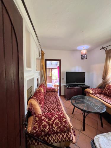 a living room with a couch and a table at Mini-Villa à deux pas de la plage in Cabo Negro
