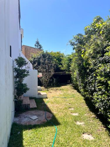 a garden with a green hose in the grass at Mini-Villa à deux pas de la plage in Cabo Negro