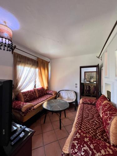 a living room with a couch and a table at Mini-Villa à deux pas de la plage in Cabo Negro