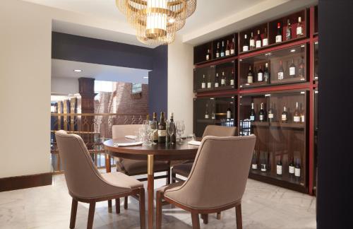 a dining room with a table and chairs and wine bottles at Hotel Royer Urbana Champaign, Tapestry Collection by Hilton in Champaign