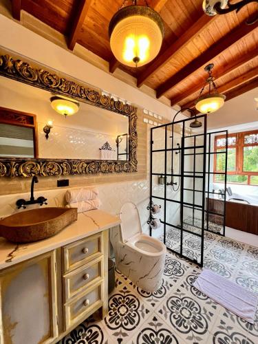 a bathroom with a sink and a toilet and a mirror at Hotel Boutique Sagrado Corazon in Abejorral