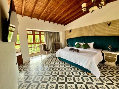 a bedroom with a bed with a cat laying on it at Hotel Boutique Sagrado Corazon in Abejorral