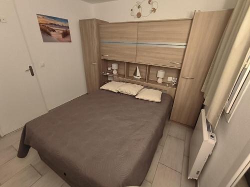 une petite chambre avec un lit dans une pièce dans l'établissement T2 Vue mer, Jardin clos, Village vacances Cap Esterel St Raphaël, à Saint-Raphaël