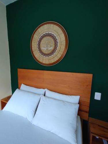 a bedroom with a bed with a green wall at Casa Amarela da Prainha de Mambucaba - Piscina aquecida in Paraty