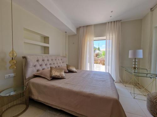 a bedroom with a large bed with a large window at Villa Arian mit tollem Meeresblick und Luxusausstattung in Gialasi in Ancient Epidavros