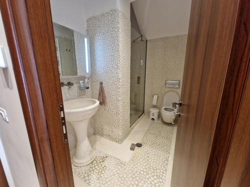 a bathroom with a sink and a toilet at Villa Arian mit tollem Meeresblick und Luxusausstattung in Gialasi in Ancient Epidavros