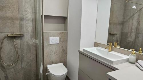 a bathroom with a toilet and a sink and a shower at Apartament w Centrum 200 m od jeziora in Olecko