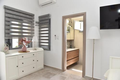 a bedroom with white cabinets and a mirror at Faros Anaplioti in Kalymnos