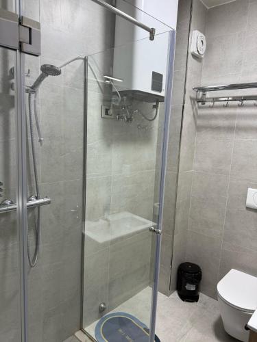 a shower with a glass door in a bathroom at STAY-FIVE rooms & apartments in Shkodër