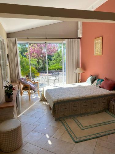 une chambre avec un grand lit et une grande fenêtre dans l'établissement Chambre de charme climatisée, avec piscine, à Grasse