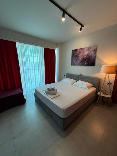 a bedroom with a large bed and red curtains at STAY-FIVE rooms & apartments in Shkodër
