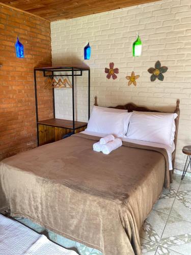 a bed with two towels on it in a room at Pousada Canto da Serra in Conceição da Ibitipoca