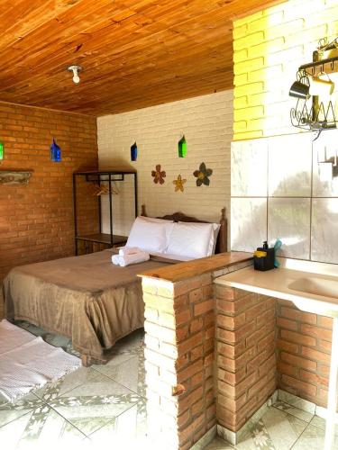 a bedroom with a bed in a brick wall at Pousada Canto da Serra in Conceição da Ibitipoca