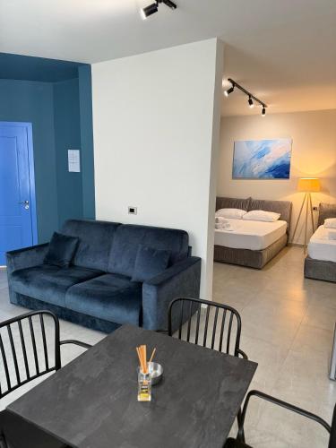 a living room with a couch and a table with chairs at STAY-FIVE rooms & apartments in Shkodër