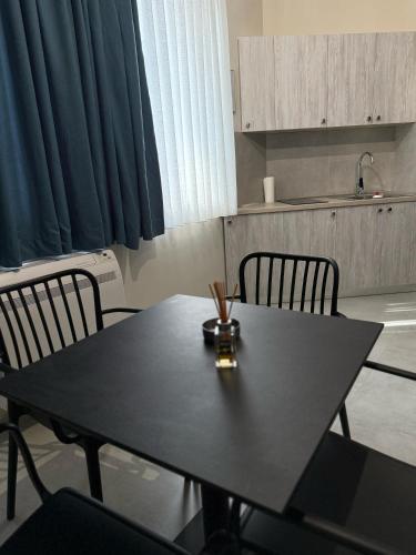 a black table with two chairs in a kitchen at STAY-FIVE rooms & apartments in Shkodër