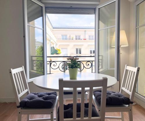 a dining room table with two chairs and a large window at Cocon familial à 8min Disney avec Parking in Serris