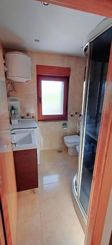 a bathroom with a sink and a toilet and a window at Vista marina VUT-7215-AS in Bañugues
