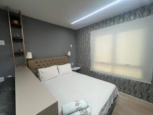 a bedroom with a white bed and a window at Blend Marista! Café da manhã Premium no Ibis! in Goiânia