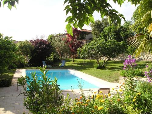 une piscine au milieu d'un jardin dans l'établissement Maison en pierre cosy avec piscine privé, à Dolmayrac