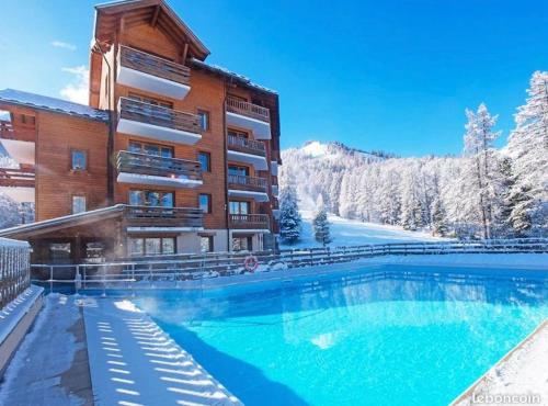 un hôtel avec une piscine dans la neige dans l'établissement Résidence Albane, T3 entièrement refait, à Vars