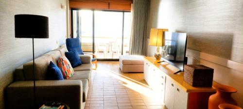 a living room with a couch and a tv at Rooms in Casa da Foz do Rio in Caminha