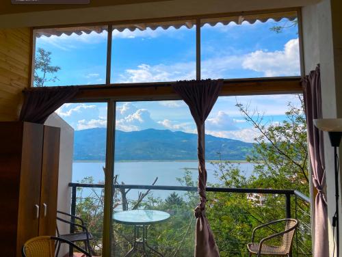 a window with a view of a lake and mountains at Lakeview Apartment in the Heart of Guatavita Bunk bed for Kids in Guatavita