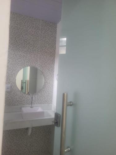 a bathroom with a sink and a mirror at Hotel Cristal in Barcarena