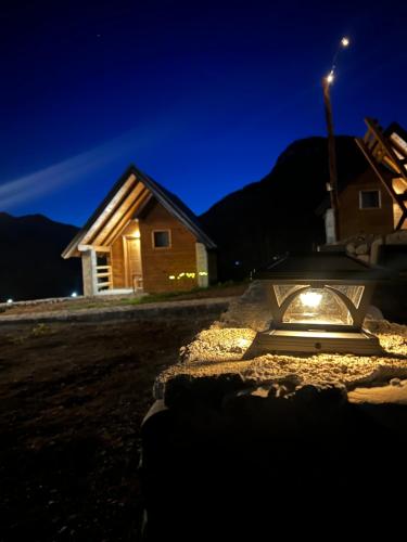 a house at night with a light in the snow at ETHNO STAR Bojović in Gusinje